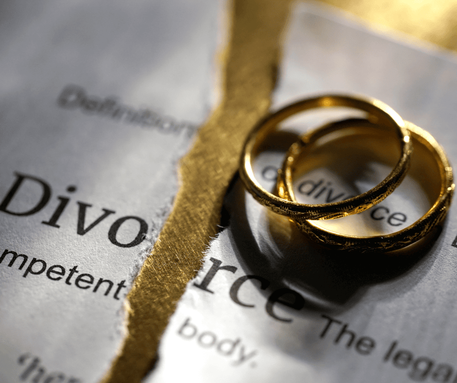 Wedding rings and torn sheet of paper explaining the definition of divorce